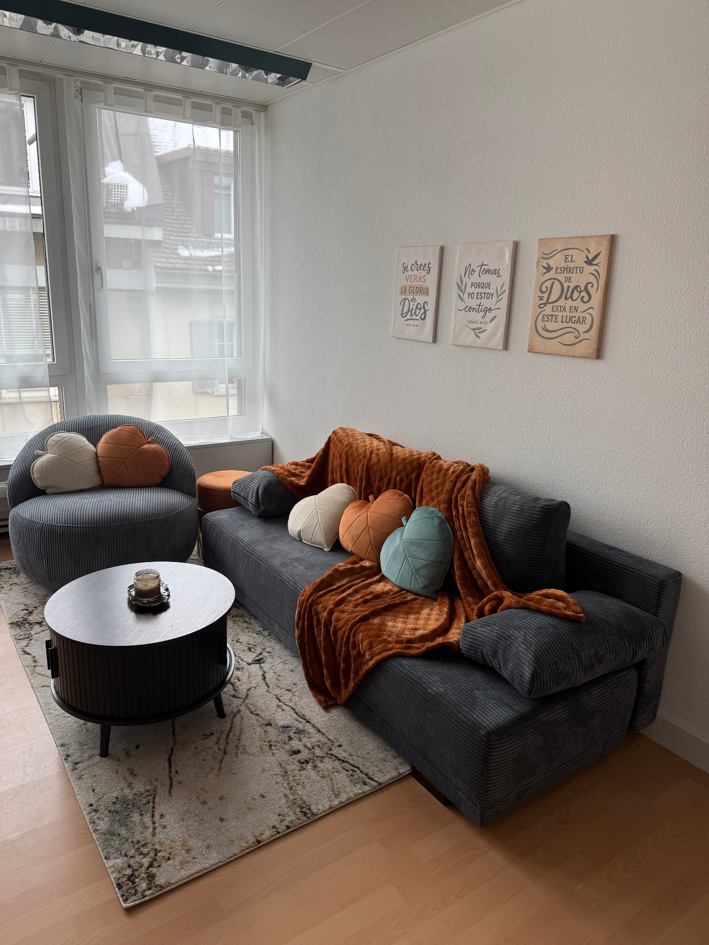 The Praxis sanctuary room — warm corduroy sofa, scripture art, candlelight